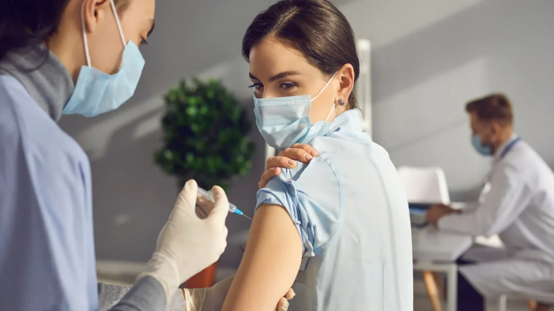 Healthcare professional vaccinating a patient, symbolising patient-centric innovation in clinical research led by Adeeb Khan.