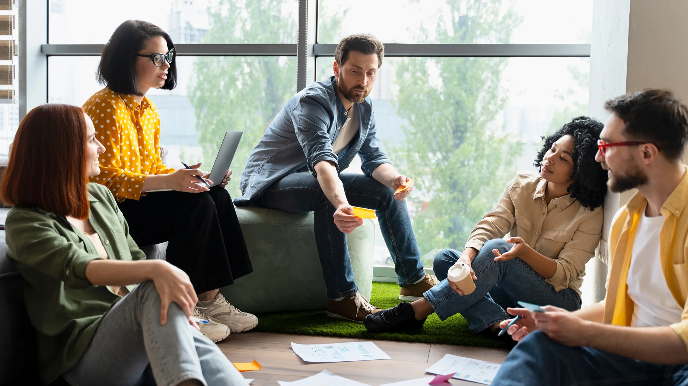 Team engaged in a brainstorming session using sticky notes in a modern office setting.