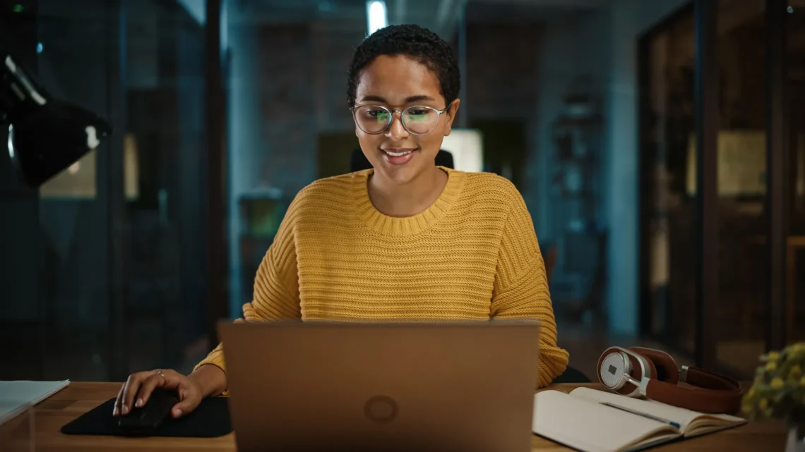 Professional working on a laptop in a modern office environment, showcasing innovation and digital design.