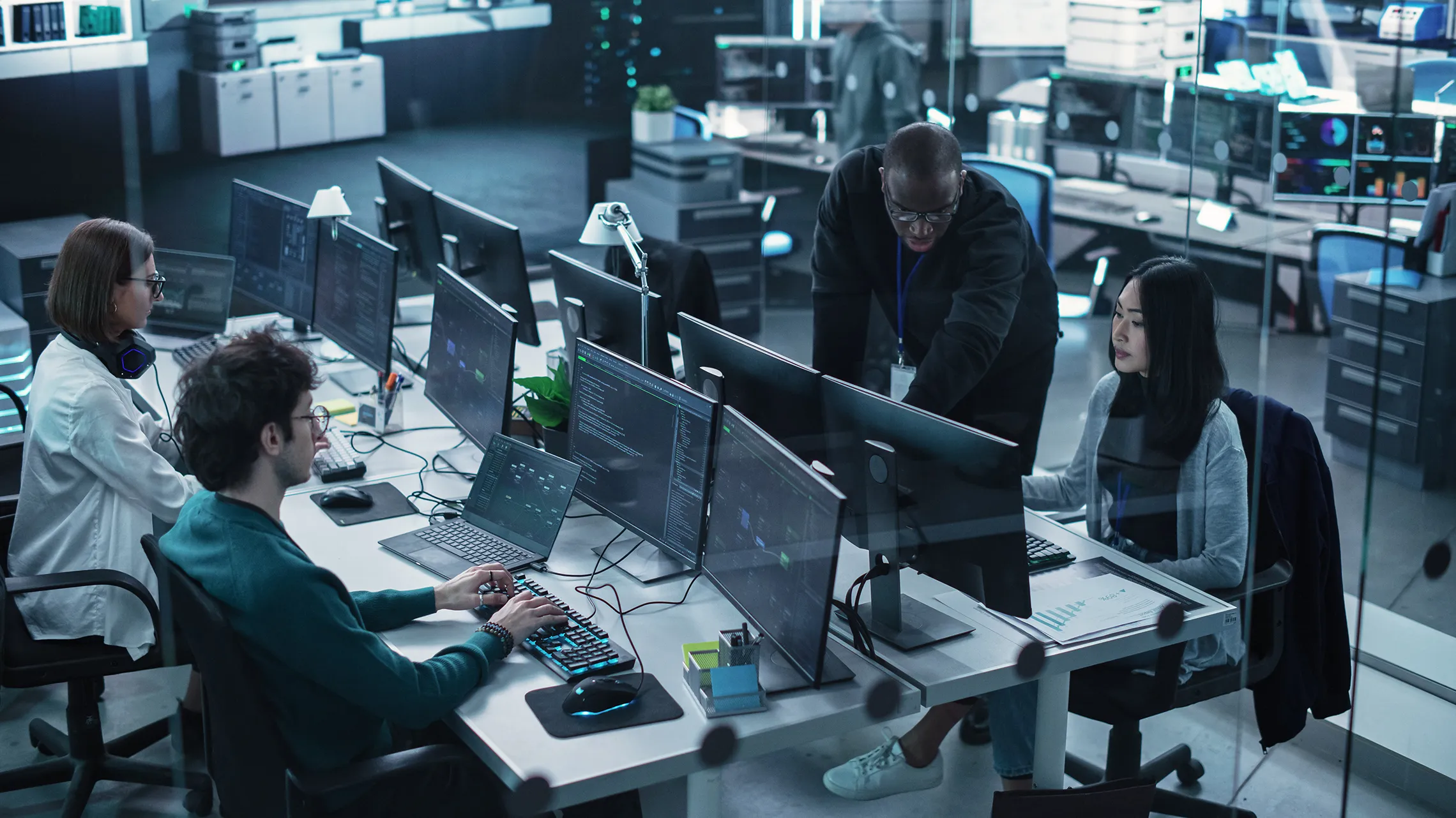 Group of IT professionals working together in a high-tech collaborative office space.