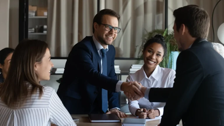 Team of consultants and Zain executives shaking hands during a successful transformation consulting meeting, driving strategic growth and innovation.